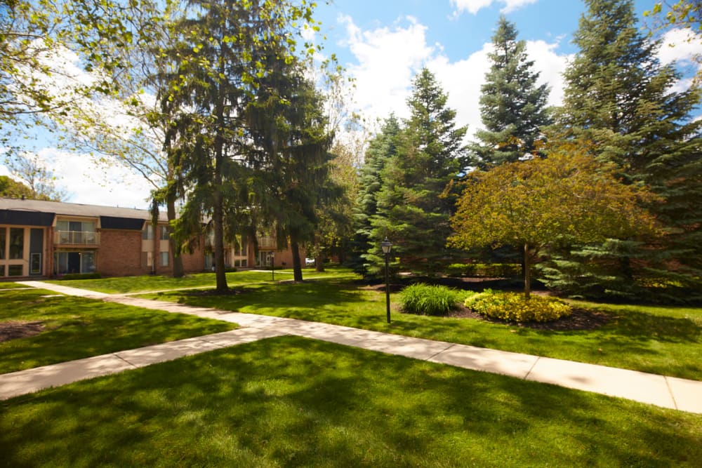 Walking paths and mature trees in the courtyard at Kensington Manor Apartments in Farmington, Michigan