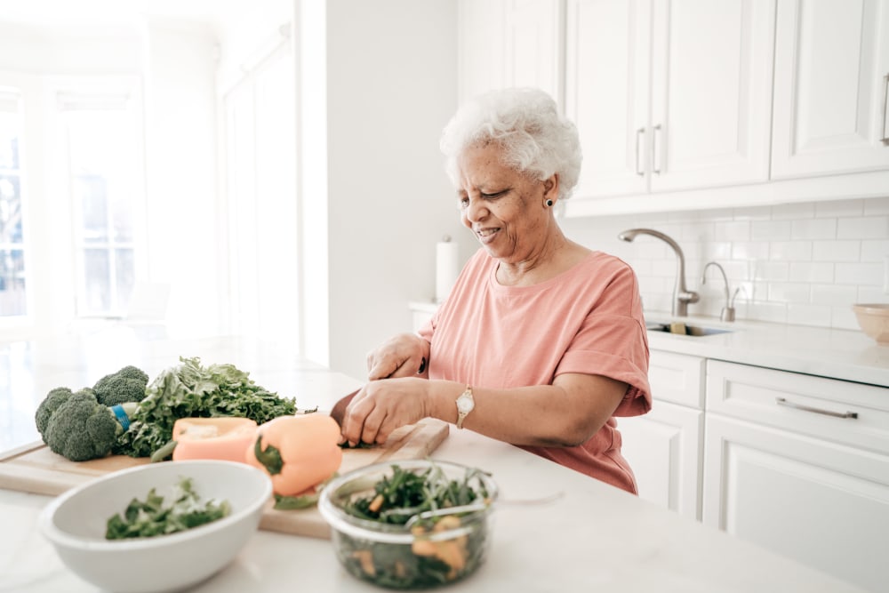 A resident preparing a meal in her kitchen at Carnegie Heights at Henderson in Henderson, Nevada