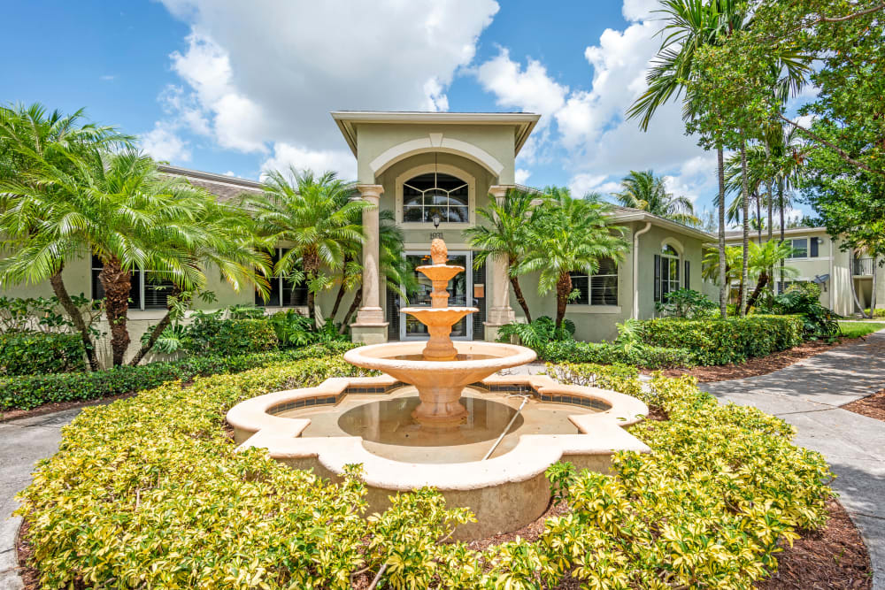 A front entrance fountain surrounded by a manicured landscape at Emerald Dunes Apartments in Miami Gardens, Florida