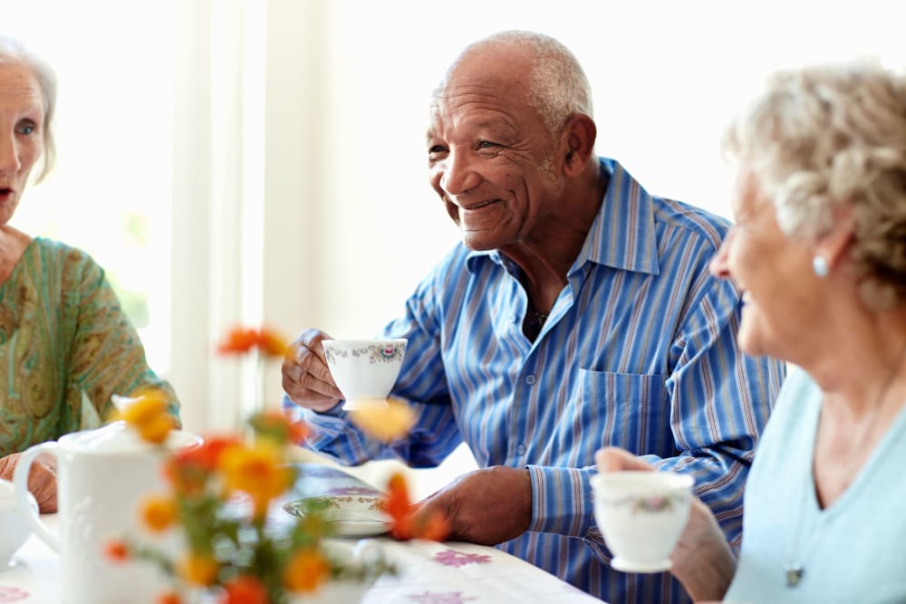 Residents sitting around a table enjoying a meal together at a Keystone community