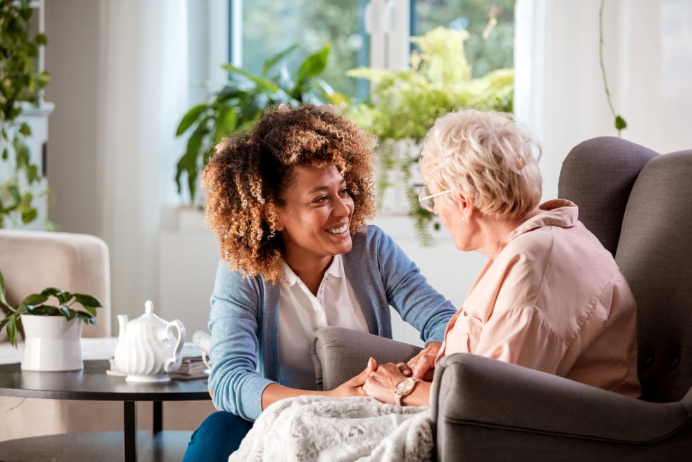 Caretaker talking to a sitting resident at a Keystone community