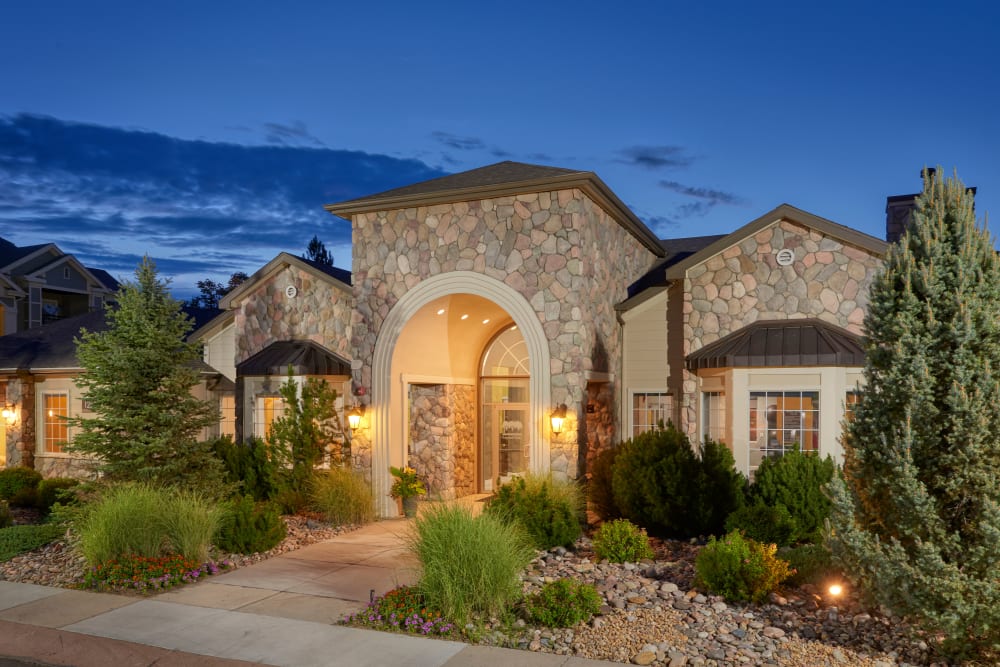 Clubhouse entrance surrounded by lush landscape at Legend Oaks Apartments in Aurora, Colorado