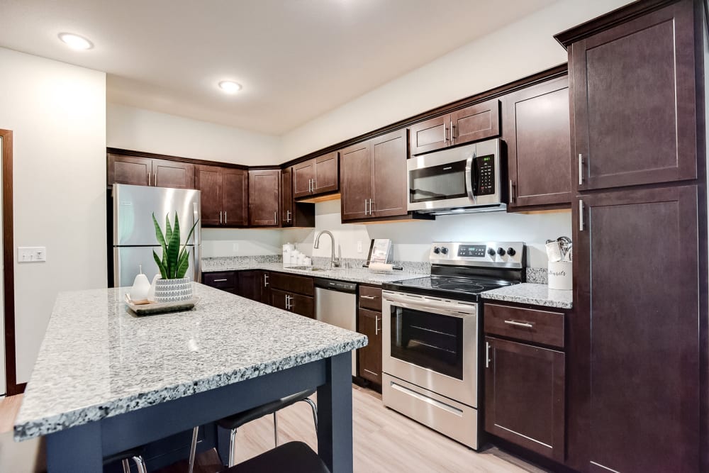 A luxury kitchen with granite countertops at Lake Jonathan Flats in Chaska, Minnesota