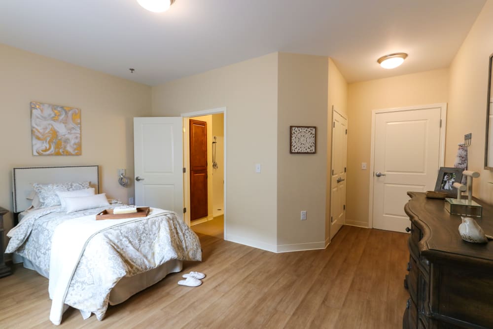 A bedroom with an attached bathroom in a shared apartment at The Harmony Collection at Roanoke - Memory Care in Roanoke, Virginia