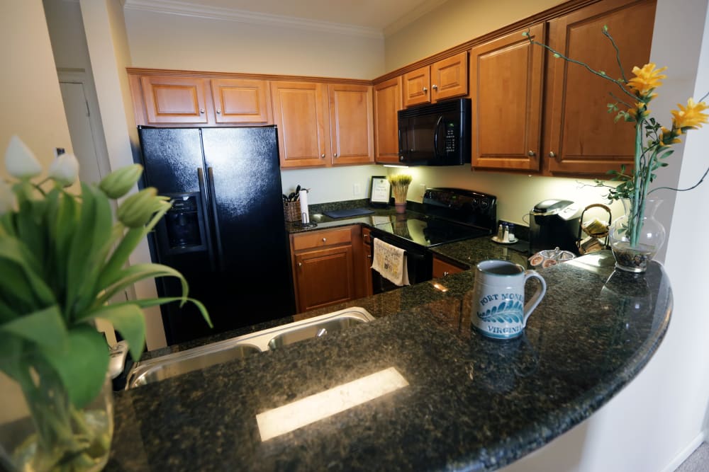 An apartment kitchen with granite counter tops at The Chamberlin in Hampton, Virginia