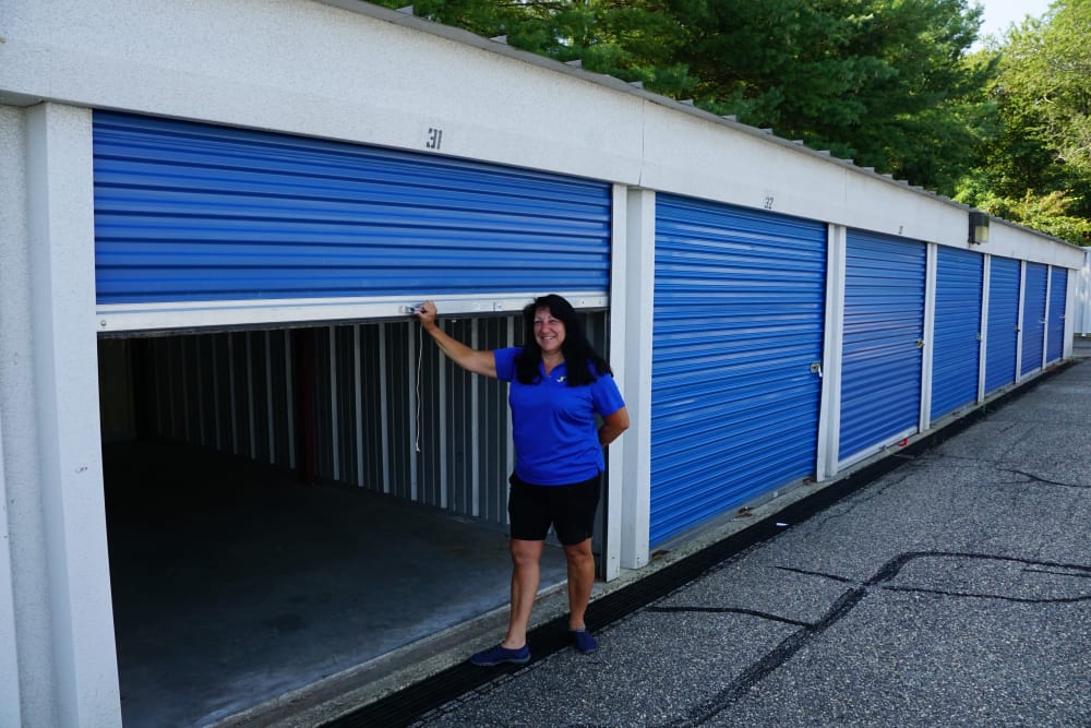 An outdoor storage unit with an employee in front of it at Store It All Self Storage - Lakeway in Lakeway, Texas