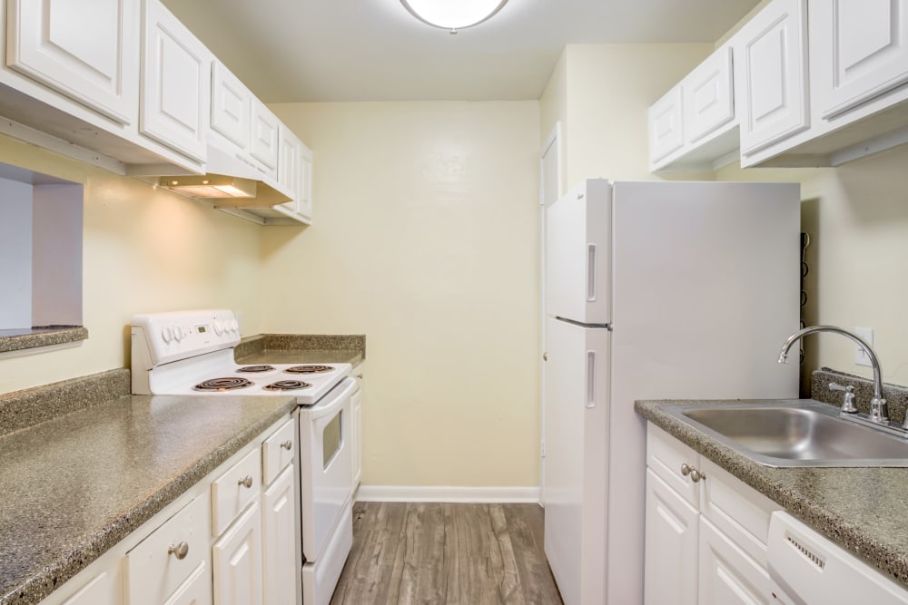 Model kitchen with plank flooring at Woodcreek Apartments in Huntsville, Texas