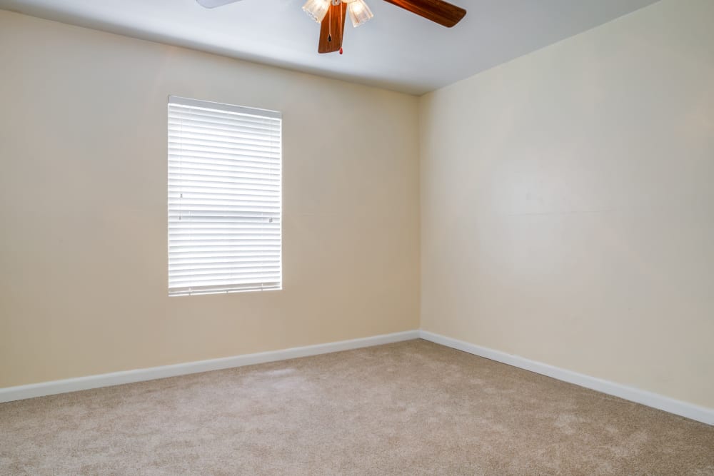 Model bedroom with ceiling fan at Woodcreek Apartments in Huntsville, Texas