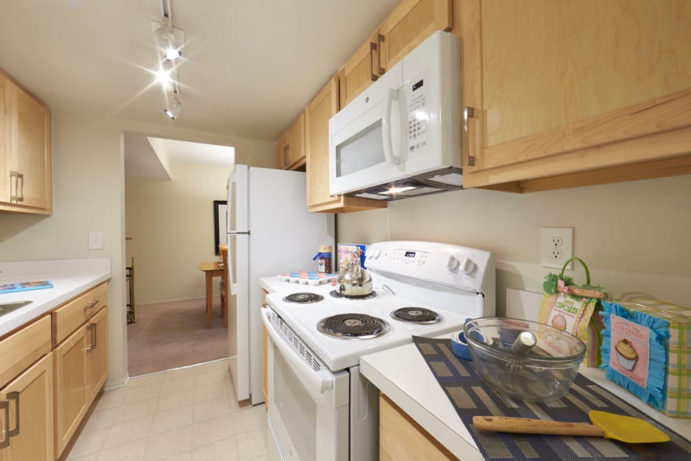 Kitchen with upgraded lighting, cabinetry, and hardware at Kensington Manor Apartments in Farmington, Michigan