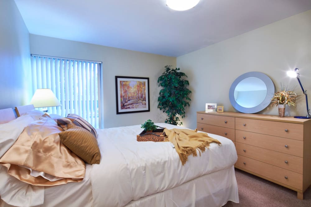 Master bedroom with plush carpeting at Kensington Manor Apartments in Farmington, Michigan