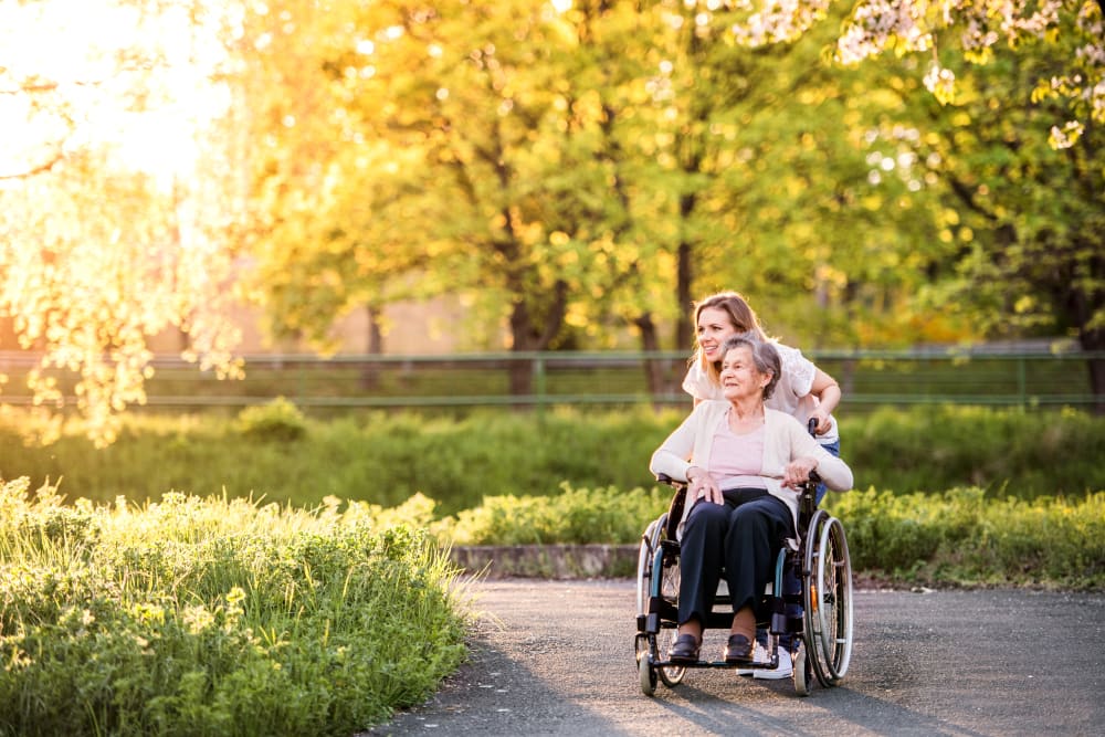 Caretaker taking a physically impaired resident for a walk around Meridian Senior Living in Bethesda, Maryland