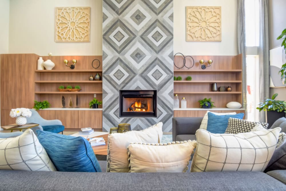 Large wrap-around couch next to a fireplace in the clubhouse at Sofi Shadowridge in Vista, California