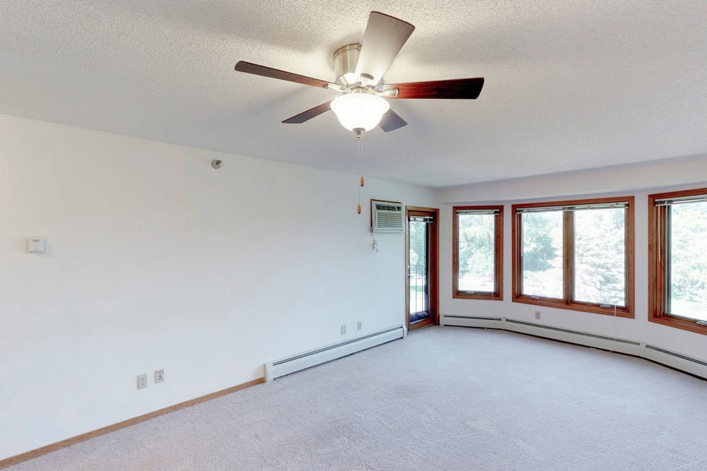 Spacious living room with a ceiling fan at Oaks Lincoln Apartments & Townhomes in Edina, Minnesota
