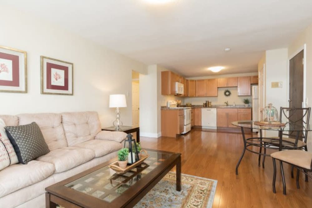 Spacious living room with wood-style flooring at Olde Hampton Village Apartments in Hampton, New Hampshire