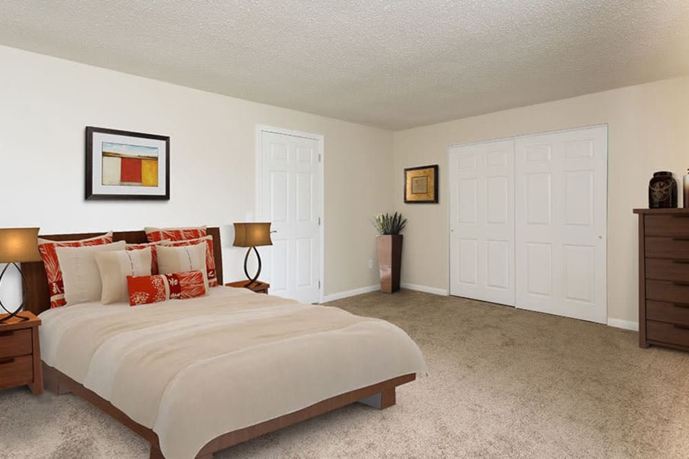 Bedroom with plush carpet at Crossroads Apartments & Townhomes in Spencerport, New York