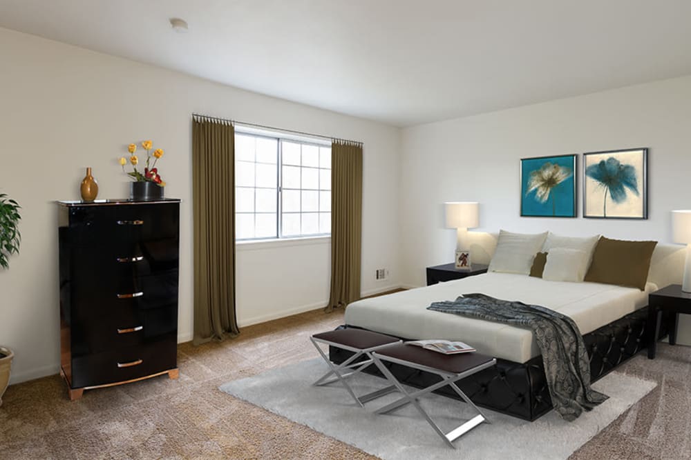 Bright, cozy bedroom at Elmwood Terrace Apartments & Townhomes in Rochester, New York