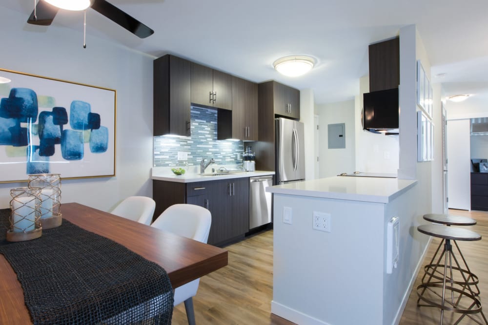 View of the modern kitchen from a model home's dining area at Sofi Belmont Glen in Belmont, California