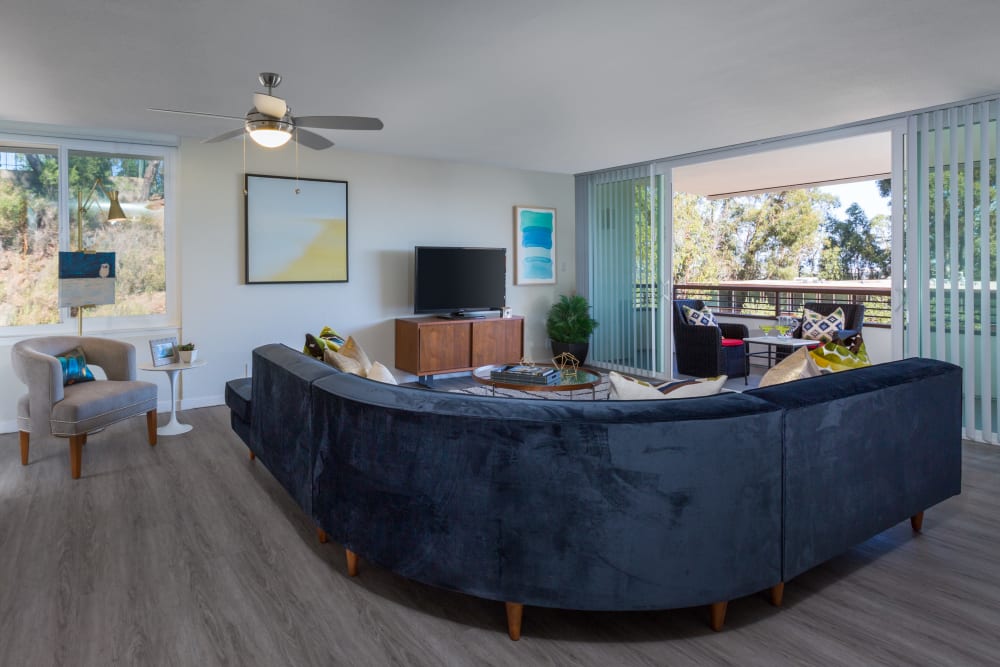 Beautiful hardwood floors and a ceiling fan in a model home's living area at Sofi Belmont Glen in Belmont, California