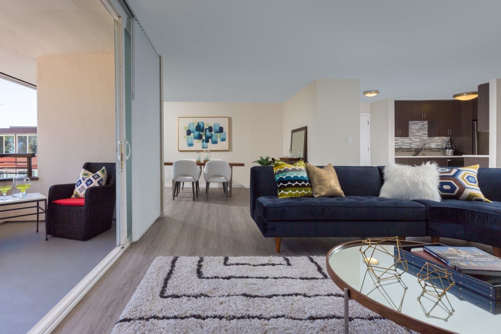 Hardwood flooring and a large private balcony outside a model home's living area at Sofi Belmont Glen in Belmont, California