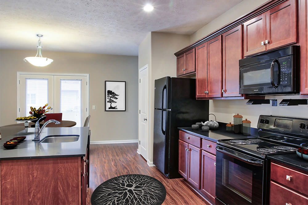 Renovated kitchen with black appliances and granite countertops at Gateway Landing on the Canal in Rochester, New York