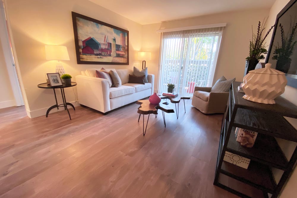 Living room with wood-style flooring at Cypress Pointe Apartments in Gilroy, California