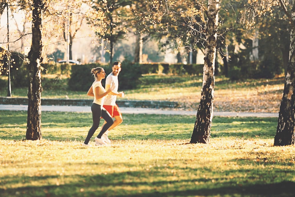 Couple on a run in a park near Cypress Pointe Apartments in Gilroy, California