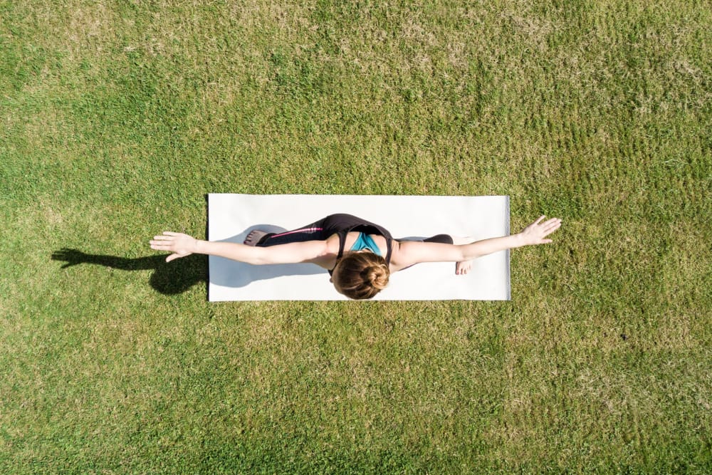 Resident doing yoga on the lawn at Greendale Apartments in Mountain View, California