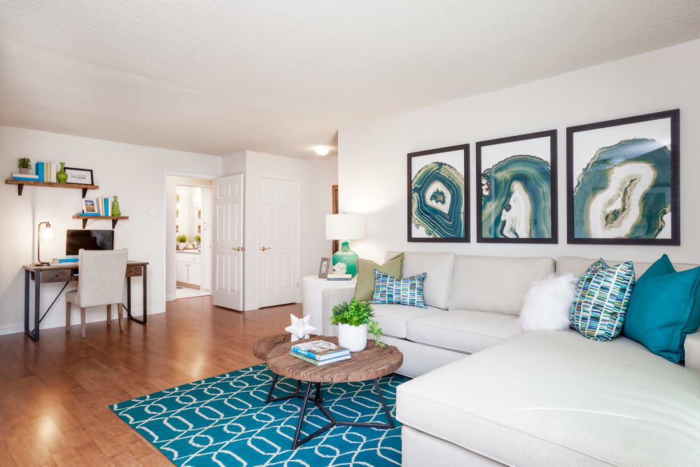 Living room with wood-style flooring at Village Green Apartments in Cupertino, California