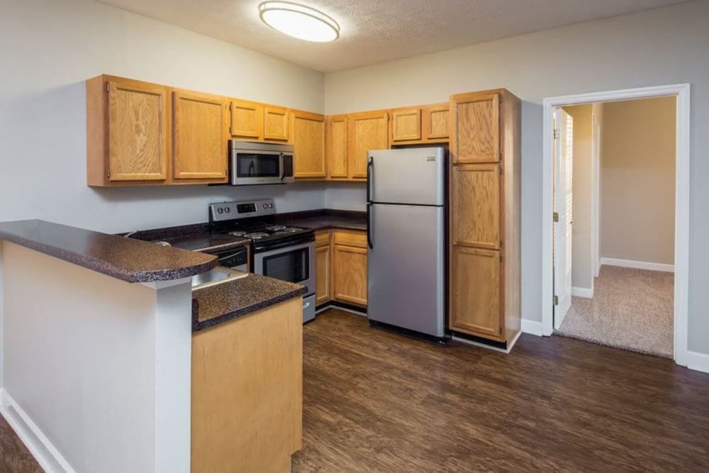 Kitchen with a breakfast bar and hardwood-style floors at Main Street Apartments in Huntsville, Alabama