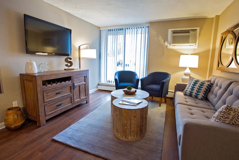 Living room with sliding door access to a private patio at Solon Club Apartments in Oakwood Village, Ohio