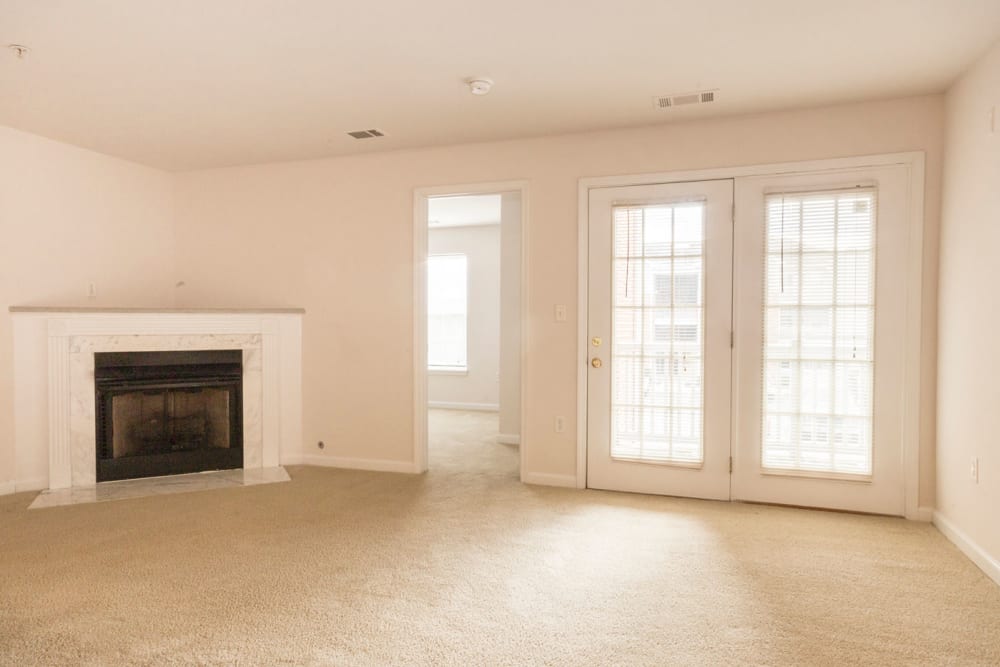 Living room with a fireplace and patio access at Glade Creek Apartments in Roanoke, Virginia