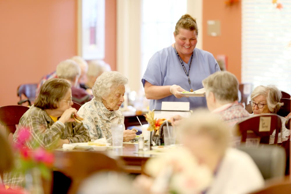 A staff member helping residents at mealtime at Providence Assisted Living. 