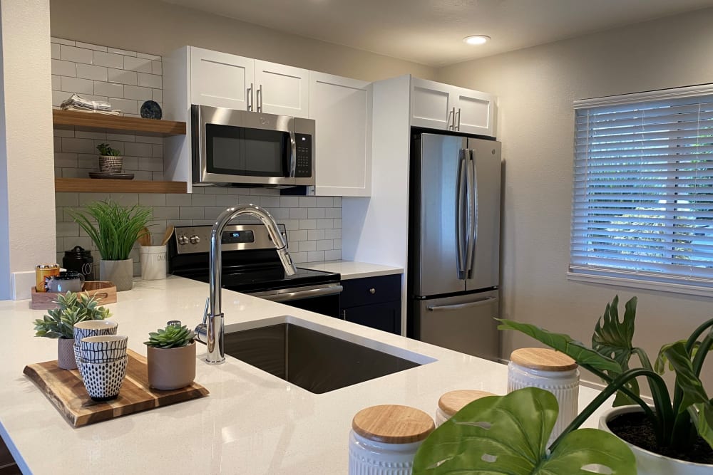 Quartz countertops and bright white cabinetry in the gourmet kitchen of a model home at Harbor Point Apartments in Mill Valley, California