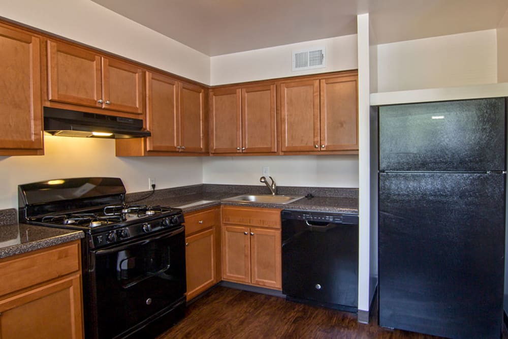 Model kitchen with new cabinets and black appliances at The Cascades Townhomes and Apartments in Pittsburgh, Pennsylvania