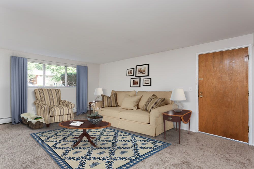 Spacious carpeted model living room at Long Pond Gardens Senior Apartments in Rochester, New York