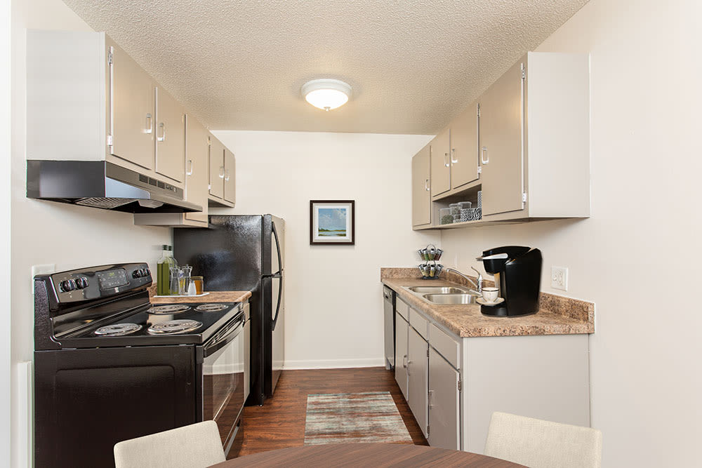 Kitchen with black appliances at Penfield Village Apartments in Penfield, New York