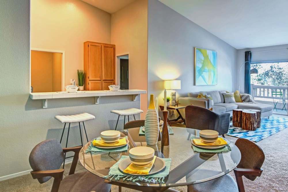 Well-decorated dining area table next the kitchen's breakfast bar in a model home at Sofi Canyon Hills in San Diego, California