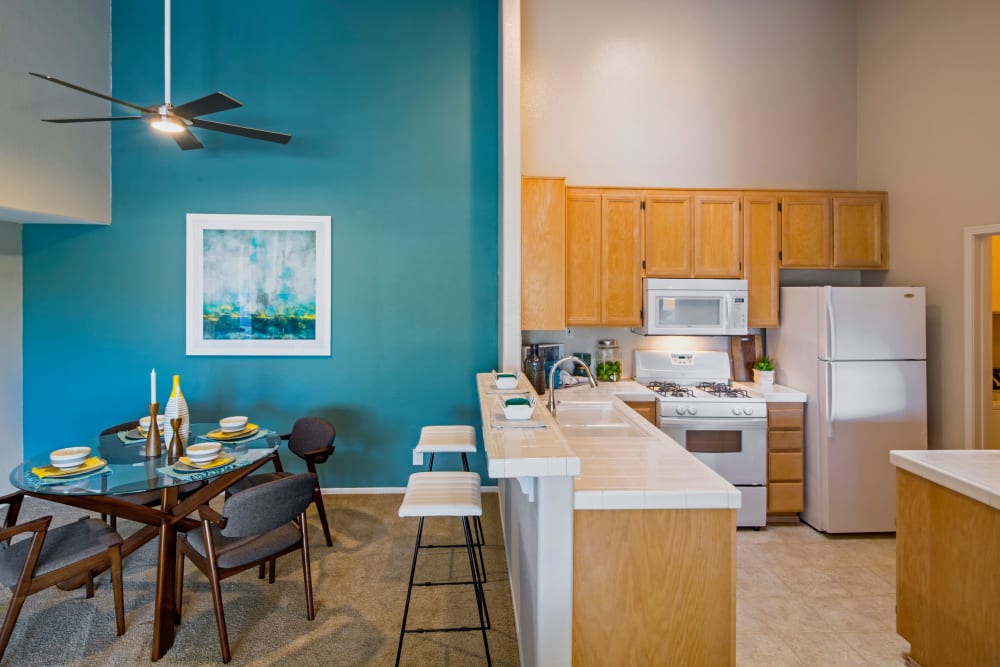 View of the dining and kitchen areas from the living space of a model home at Sofi Canyon Hills in San Diego, California