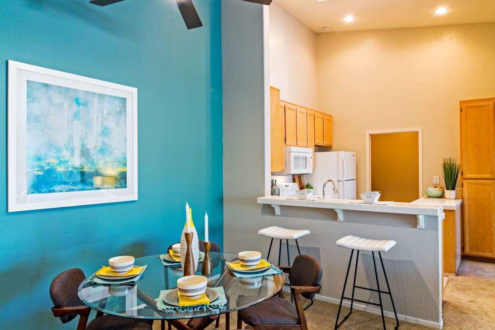 Dining area with an accent wall next to the kitchen of a model home at Sofi Canyon Hills in San Diego, California
