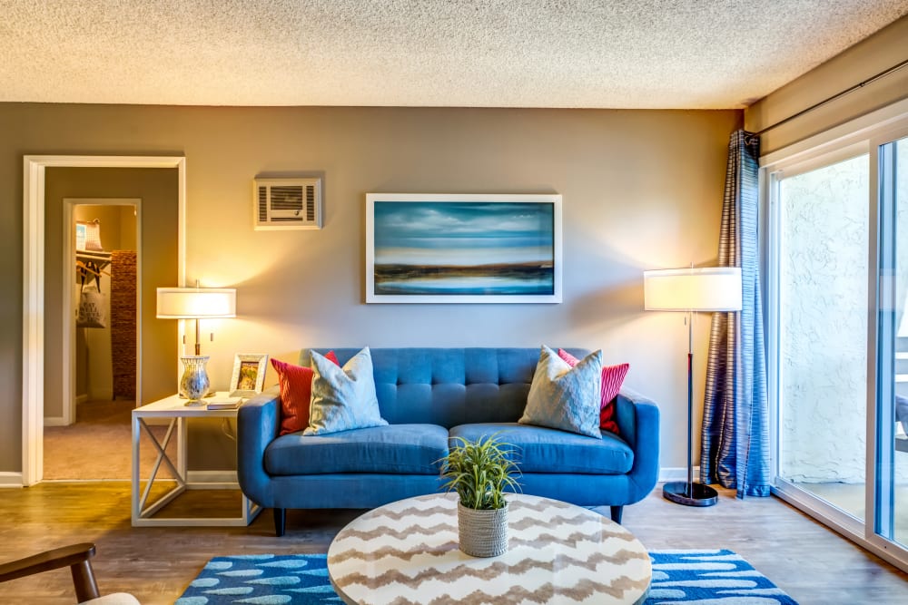 Well-furnished living area with sliding glass doors leading to the private balcony of a model home at Sofi Poway in Poway, California