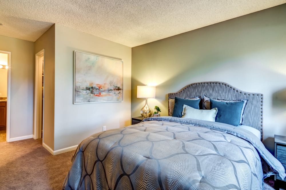 Well-furnished master bedroom with an en suite bathroom in a model home at Sofi Poway in Poway, California