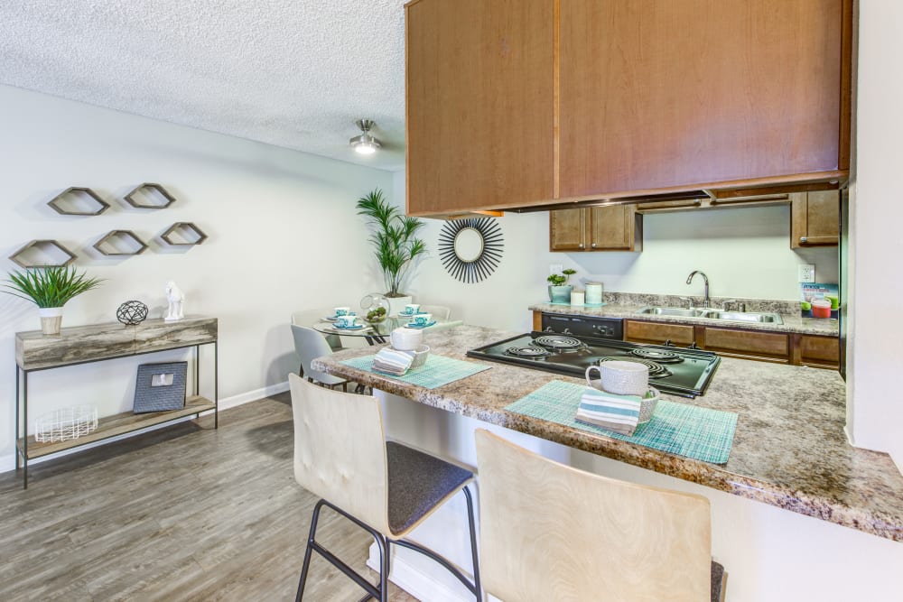 Kitchen with a breakfast bar and granite countertops in a model home at Sofi Poway in Poway, California