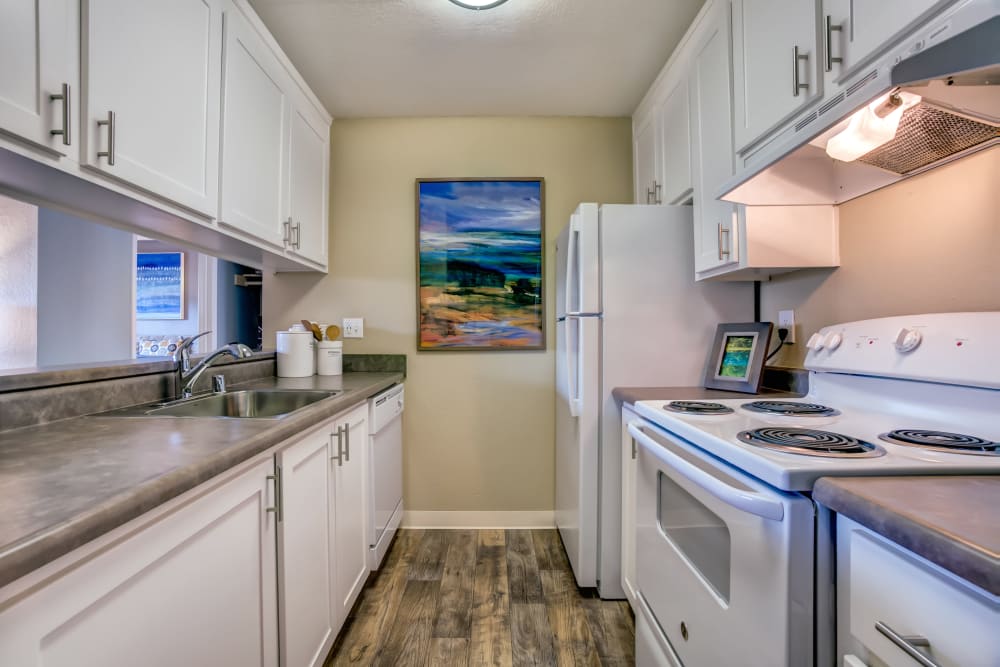 Modern kitchen with granite countertops and ample cupboard space in a model home at Sofi at Los Gatos Creek in San Jose, California