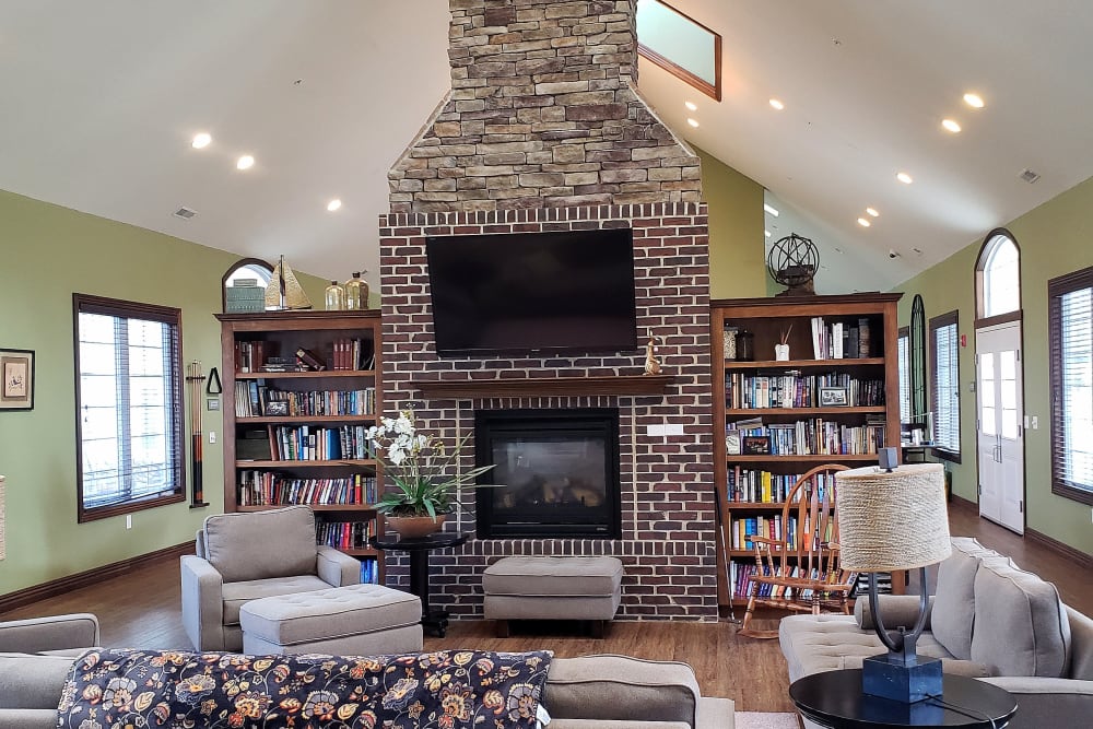 Community clubhouse with books, tv, and a fireplace at Villas of Holly Brook Chatham in Chatham, Illinois