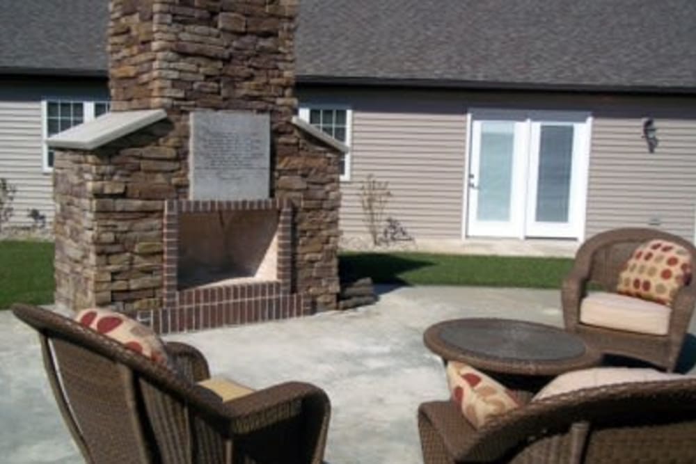 Outdoor patio with a fireplace and seating at Villas of Holly Brook Shelbyville in Shelbyville, Illinois
