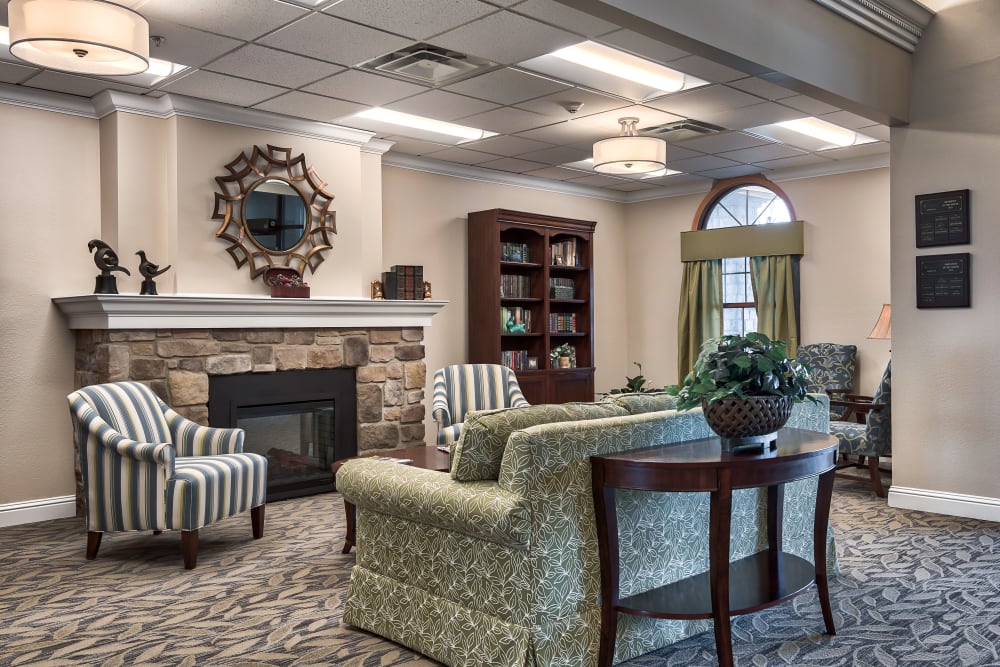 Fireside seating next to a bookshelf at Oak Pointe of Warrenton in Warrenton, Missouri
