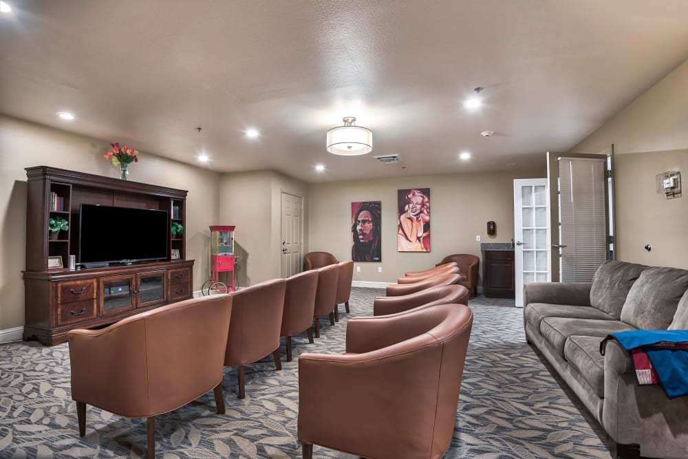 Large media room with rows of seats across from a big tv at Oak Pointe of Warrenton in Warrenton, Missouri