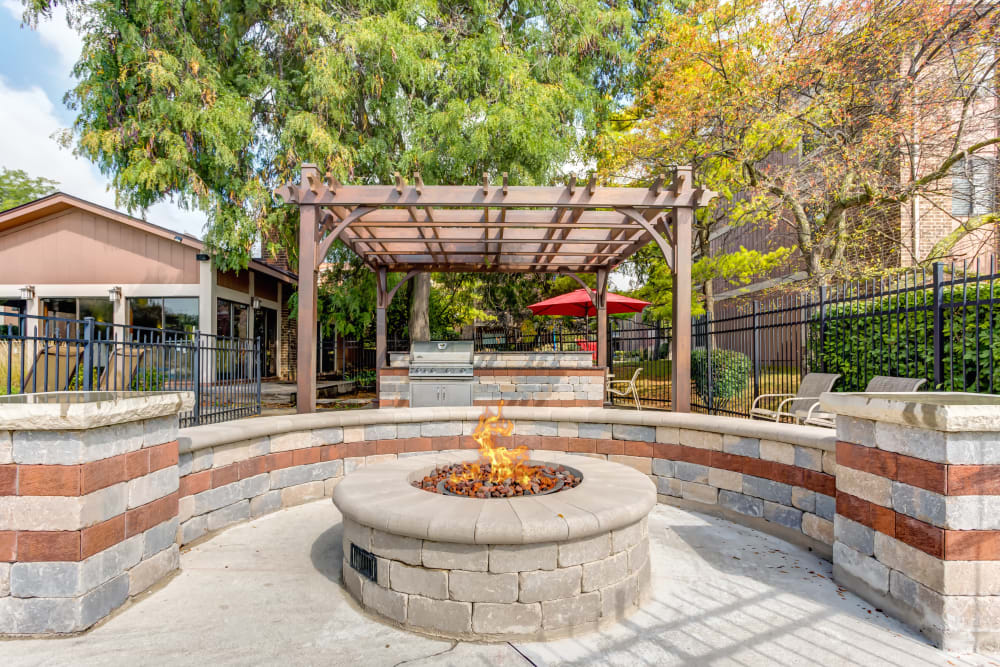 Outdoor fire pit with a grill in the background at Lakeside Apartments in Wheaton, Illinois