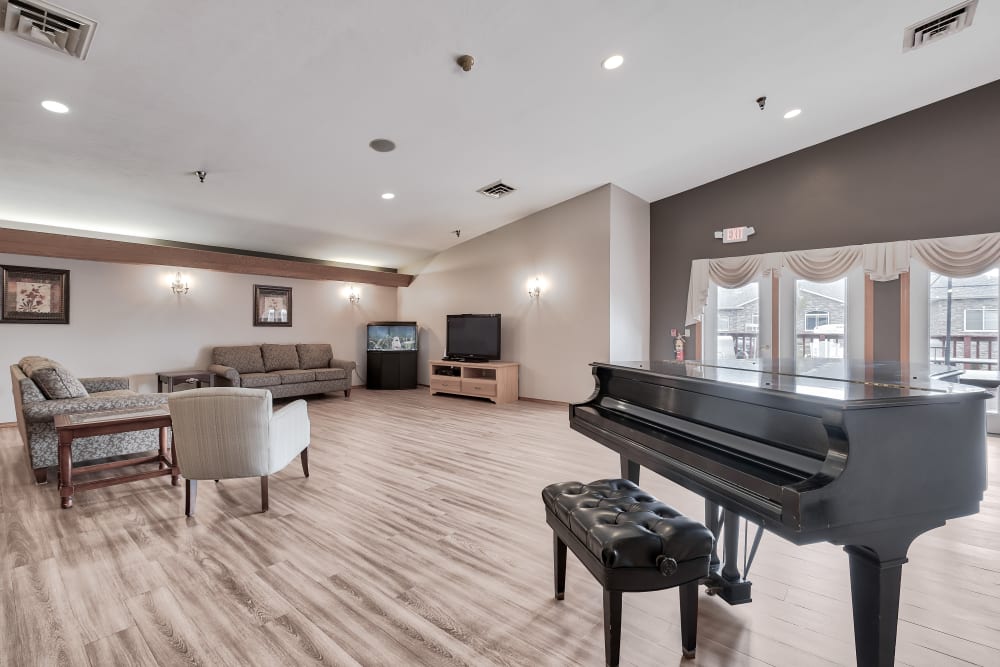 A community visiting area with a piano at Bishop's Court in Allouez, Wisconsin
