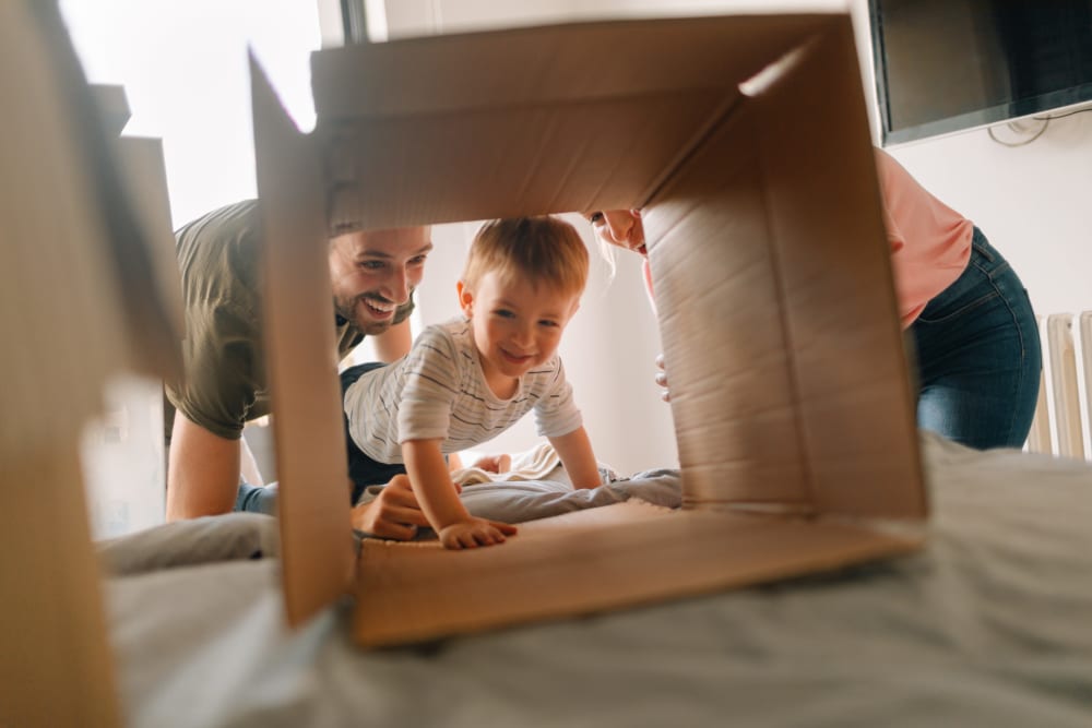 A young child crawling through a box near Hayward Storage LLC in Hayward, California